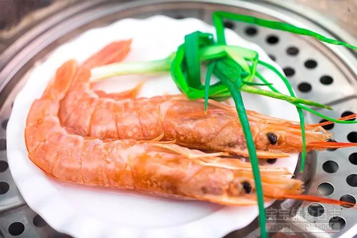 在等待的过程中，我们先将红虾洗净，放上葱，再放入蒸锅中蒸熟（妈妈们也可以用刀尖将虾筋弄断可以防止受热后虾身卷曲，方便后续剥壳）；（蒸虾时，大火蒸开后，转成中火蒸，可以防止虾变老。）