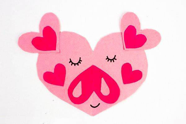 步骤2：接着，把我们剪出来的大小心贴成个小猪脸蛋，眼睛和嘴巴用马克笔画一下。