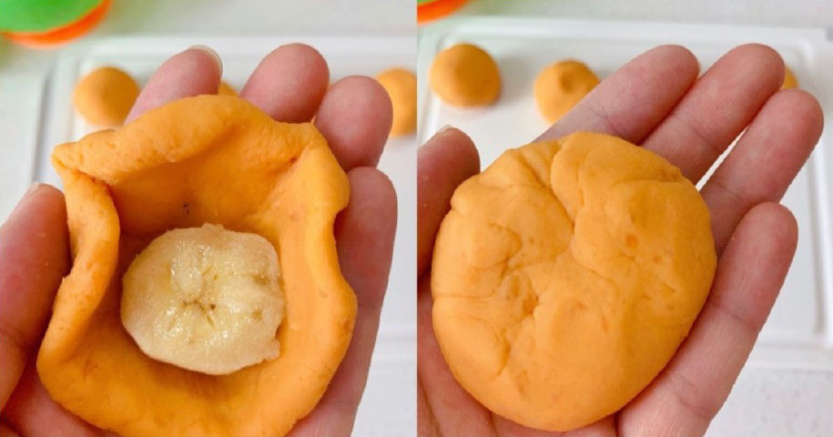 将面团球压扁，包一块香蕉，然后封口，搓成球。