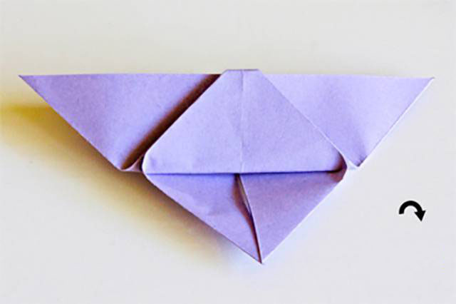 步骤9：顶角超出部分向下折叠藏到纸张后面。