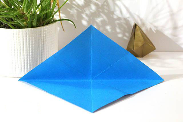 步骤2：然后沿着两条对角线对折一下打开，在纸张上形成一个米字形状的折痕。