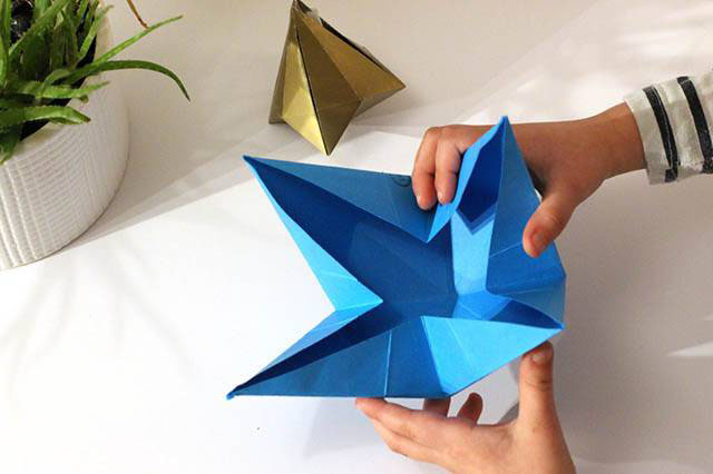 步骤6：把纸张中心位置向下推，四个角向上向中间压。