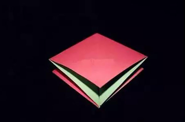 步骤3：利用折痕收折折纸，压平放置(红颜色朝上)。