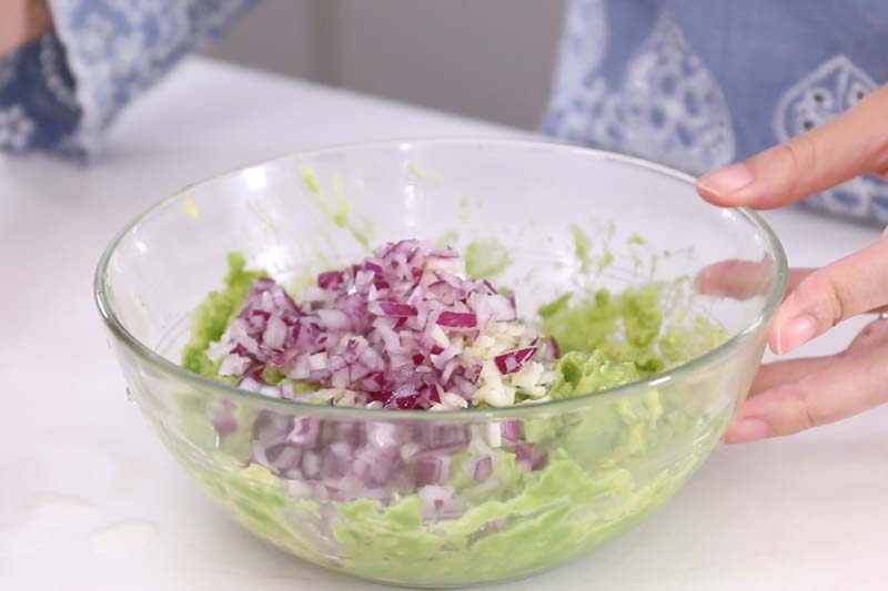 紫洋葱及蒜头切碎，拌入牛油果酱中。 