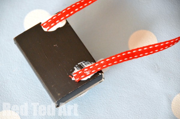 步骤5：在相机背部用胶水粘上丝带。