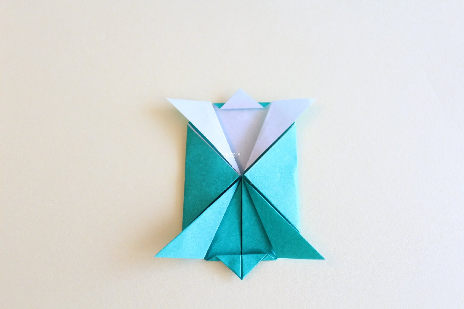 步骤8：将剪开的折纸依次向外翻折，下层的尖角部分稍微叠加进行折叠。