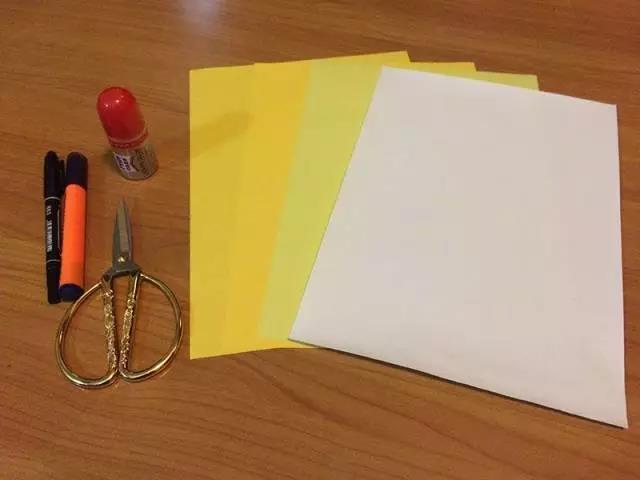步骤1：准备材料：浅黄色A4纸1张，深黄色A4纸2张， 白色A4纸一张，剪刀，胶水，黑色马克笔，橘色荧光笔