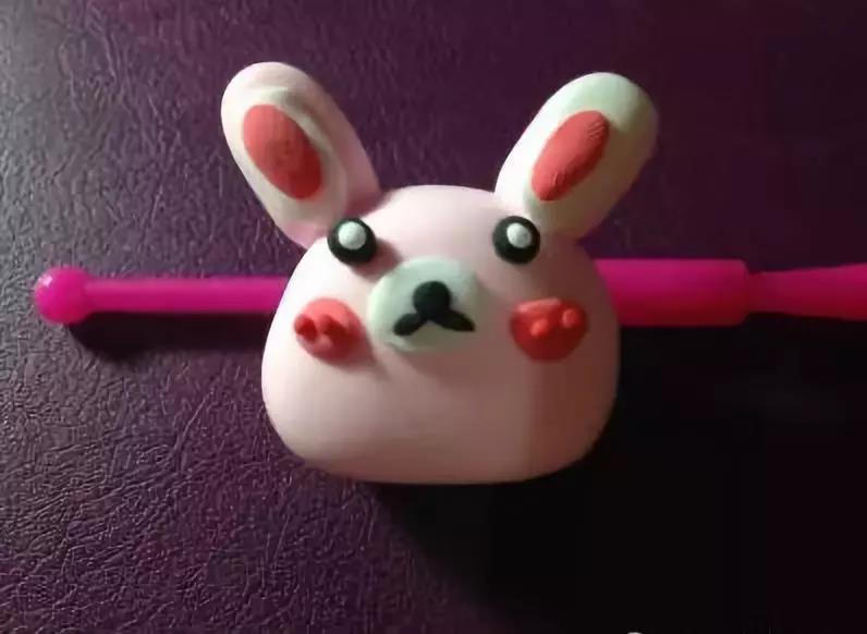 步骤7：用深粉色的粘土给兔子做一下装饰，可以在脸上粘上两个腮红，在耳朵上也弄上一点深粉色;