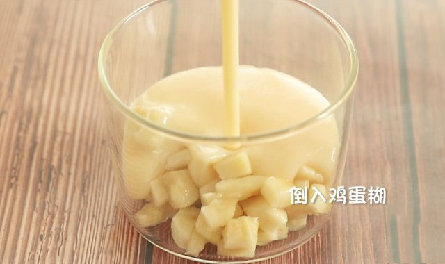 香蕉切成小块儿铺入容器底部，倒入混合后的牛奶鸡蛋米糊，用勺子撇去表面冲起的泡沫。