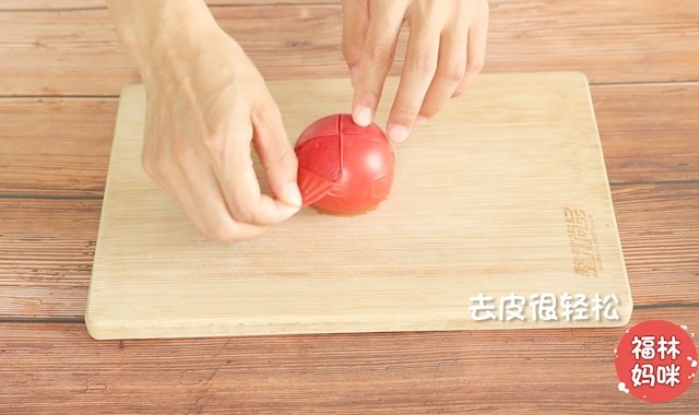 西红柿顶部划十字，放在沸水里煮一会儿，去除外皮。