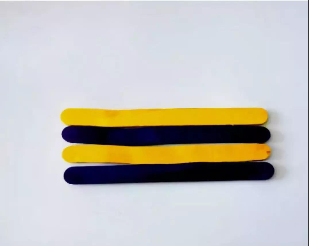 步骤3：把黄色和紫色冰棒棍交替粘贴在卡纸上。 只有颜色对啦，你的蜜蜂才能活里活现