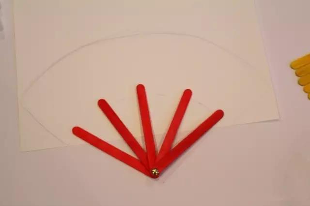 步骤3：对照扇骨，在白纸上画出扇面后剪下来。用水彩笔给扇面和扇骨上色。