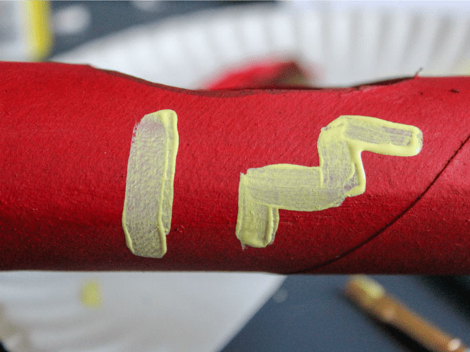 步骤4：用红色颜料给车身上色，等待颜料干后用画笔在车身上画出装饰符号(其他小部件也涂上颜色)。