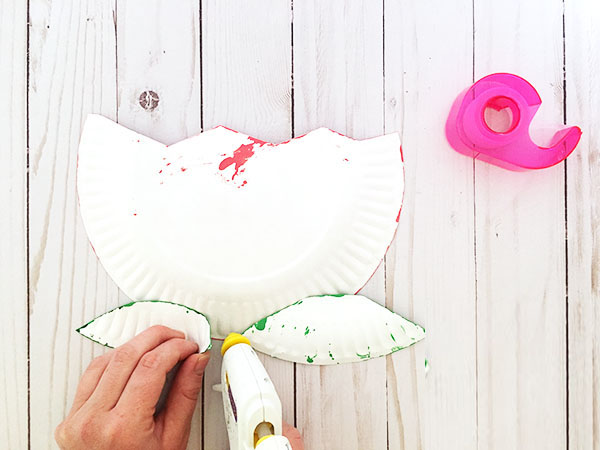 步骤4：用胶水将叶子粘贴到花朵的背面。