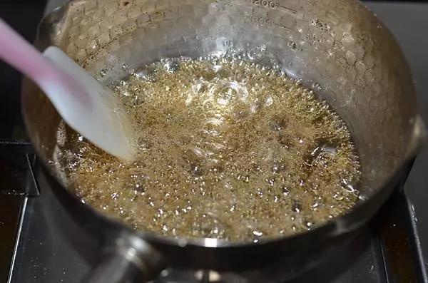用中火慢慢煮至冰糖融化，转小火一边煮一边轻轻搅拌至糖浆粘稠。