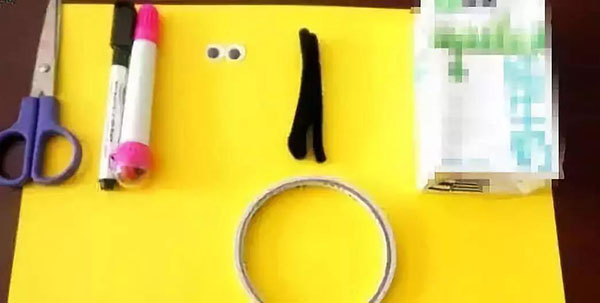 步骤1：牛奶盒、活动眼睛、黄色卡纸黑色笔、红色笔，双面胶纸、剪刀、黑色扭扭棒，胶水