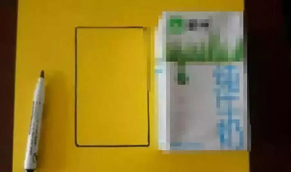 步骤2：将牛奶盒放在黄色卡纸上，然后描出牛奶盒六个面的边框，然后裁剪出来;
