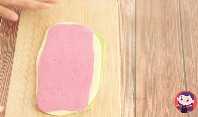 将三种颜色的面团叠压在一起。