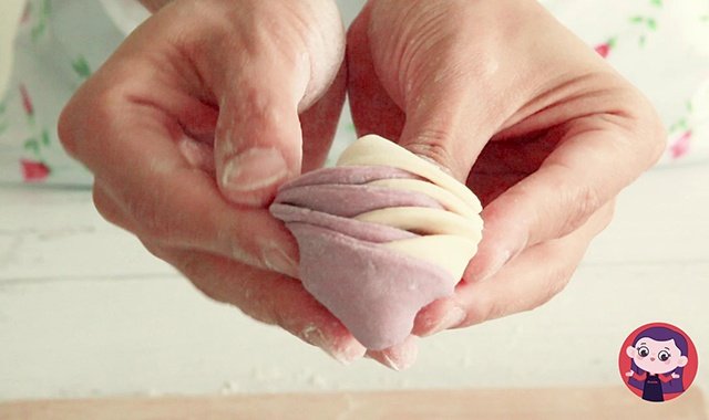 用手捏起两端，向后绕起，两端面团在后放汇合捏紧固定。