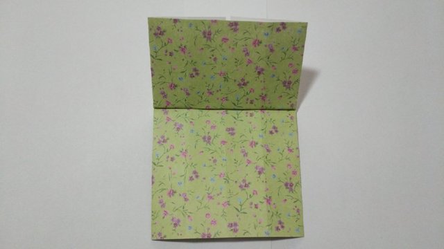 步骤7：接着把最上面的短的那一面纸张往上对折，注意要沿着上面2个小角的底部边缘往上对折。