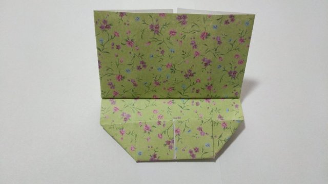 步骤12：接着把中间多余的纸张塞到底部的船型里面，边缘对齐船型的上边。