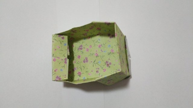 步骤16：撑开之后，把纸张边缘的棱角折出来，这就是小床的底部。