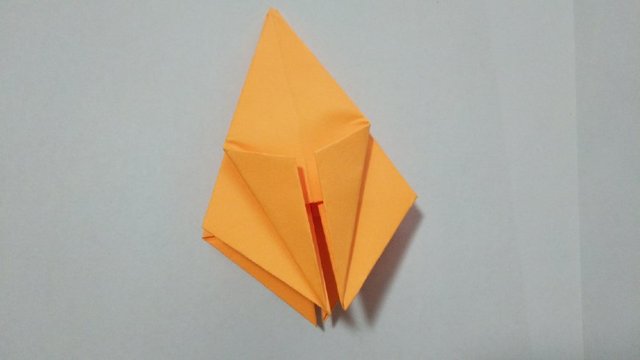 步骤5：4个角都折好之后，然后把最前方的纸张的下面的左右2边的纸往中间对折。