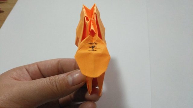 步骤19：然后把头部最下面的三角往里对折，2边折小角，让头部圆滑一点，最后画个“王”字，这里自己随意发挥就可以，主要折出老虎的脑袋和头部来就行。