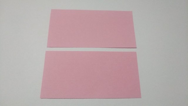 步骤1：准备材料：这里呢我用的是12cm的正方形，把它从中间对折剪开，一分为二，因为折纸花球需要的是长宽比1:2的纸张。这个长度做出来的花球2只手托起来刚刚好，我个人觉得稍微有点大，你们根据自己的喜好来哈。