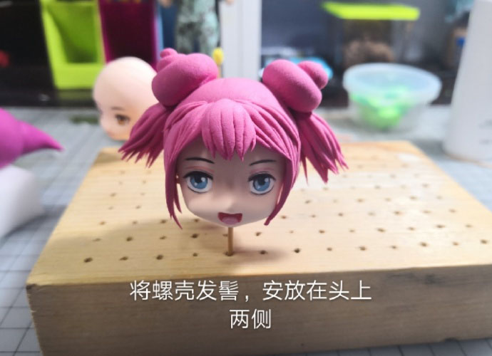 步骤14：将螺壳形状的发髻安放在头部两侧。