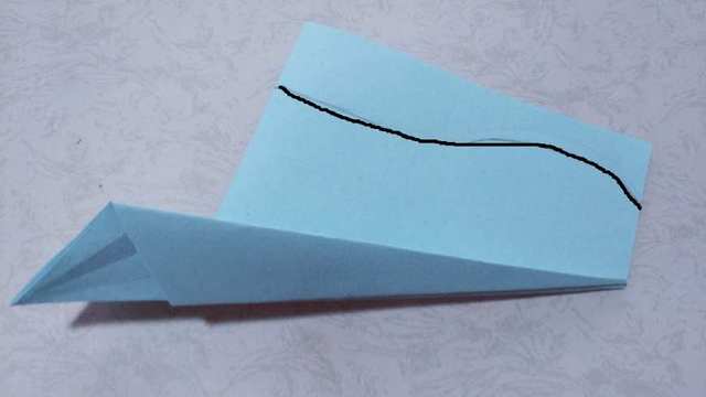 步骤12：同样的反过来，另一边的纸张也是同样的折法，然后再沿着我图上在飞机尾部画的黑色曲线，用剪子裁剪掉多余的部分。