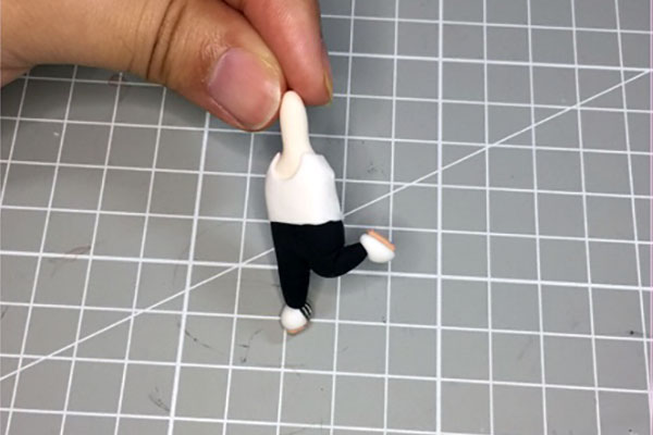 步骤1：用肉色粘土捏出身体形状，黑色黏土捏出裤子，如下图