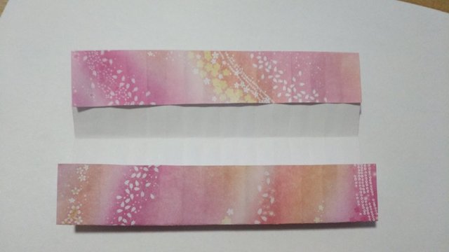 步骤8：然后把2边的纸张往中间对折，对齐2边第2道折痕，也就是中间留一道折痕的空白。