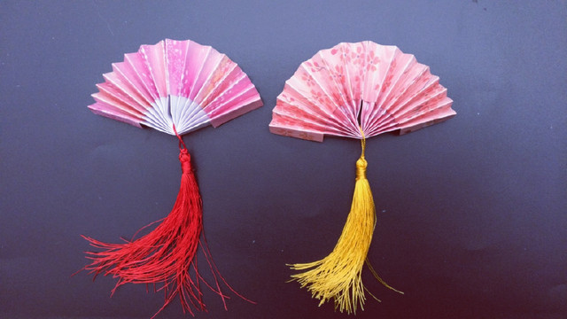 步骤11：最后，再把做好的流苏挂在扇子上，就这样，一把漂亮的小扇子就折好了，是不是很简单呢？