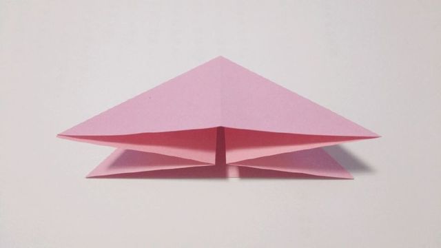 步骤2：然后把纸张从中间沿着折痕折出三角形的样子。这样一共是4个角。