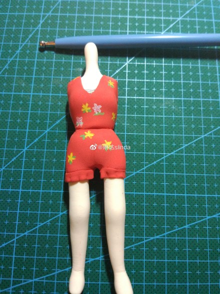 步骤2：红色的粘土捏出来人偶的身体部分，花色的衣服，很好看吧！