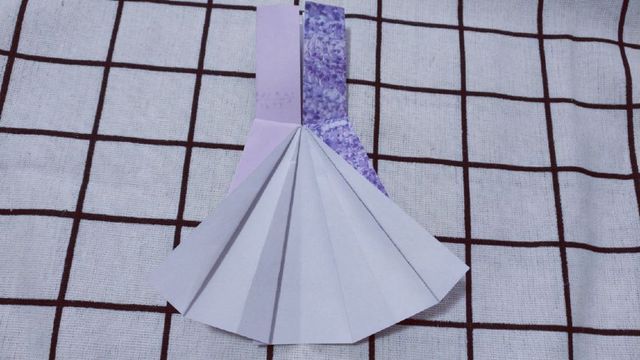 步骤9：连衣裙的一边裙褶做好之后，接着把左边的裙褶也折出来。