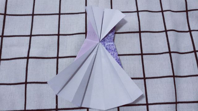 步骤10：接着来把连衣裙的后背折出来，纸张往2边对折，穿婚纱礼服，都要露背的，背美才是真的美。
