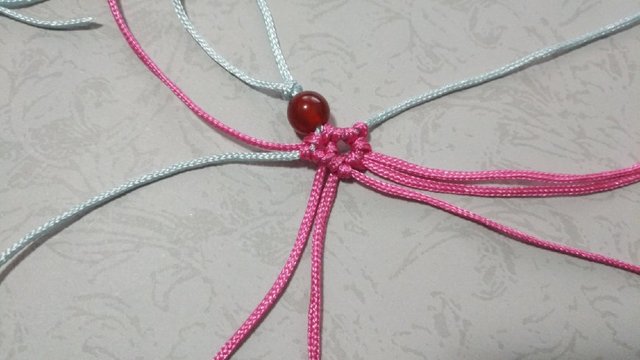 步骤9：然后粉色绕线在轴上做一个斜卷结。拉紧后的样子就是下图。