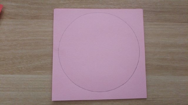 步骤1：做法非常的简单，首先准备一张正方形的纸，没有正方形的其他的也可以，因为我们需要的是圆形纸，用正方形画起来比较方便，我这里做演示用的纸张比较小是10cm的，做出来的灯笼用一只手能托住，不算太大，所以你们可以用的纸张大一点，先再纸张上画一个圆，然后把纸张沿着画线剪出圆形来。