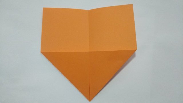 步骤2：然后左右对折，折出中间的折痕，接着把纸张2边的角往中间对折。