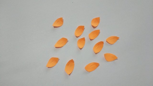 步骤9：凤凰的头部和尾巴折好后，然后把翅膀撑开，接着再取一张同颜色的纸来，剪出一片片的小纸片。