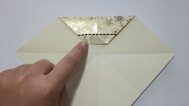 步骤2：对折好了之后，翻到背面，把顶端的大三角往下对折，然后再往上对折，折出一道中间的折痕，中间的折痕就是我用黑色线标注的，然后把纸张展开，把最下面的三角往上对折，对齐中间黑色的折痕。