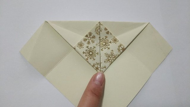 步骤7：翻到反面来，把前面的大三角对齐中间正方形的顶端往下对折。