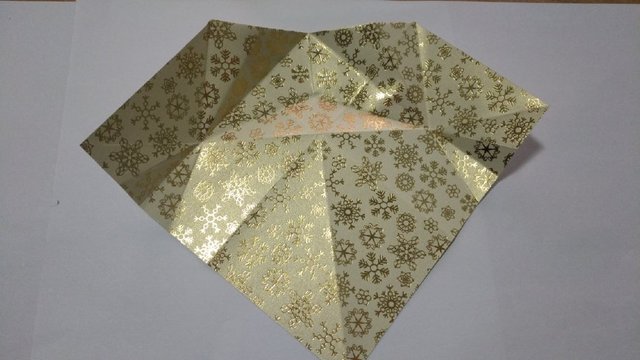 步骤8：然后翻到正面，把纸张打开，顶端的三角不用展开。