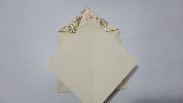 步骤12：然后沿着折痕把纸张往下压平，就是一个大的正方形。