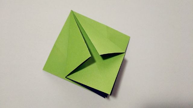 步骤3：4个角全部折叠成正方形之后，然后把纸张的左右2个角往中间对折，对齐中间的折痕，然后反过来，另一边纸同样的往中间对折。