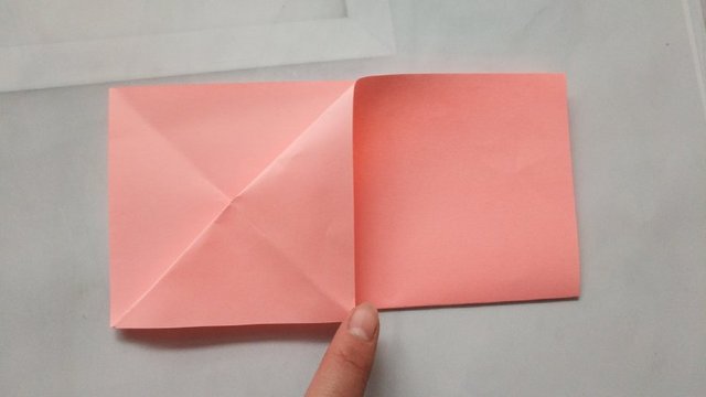 步骤3：对折好了之后，先把纸张的左边斜向上对折，注意这里折痕不要全折，只折中间的位置就可，然后再把上面的纸张往下对折，2次对折的交叉点折出来。