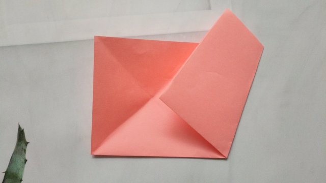 步骤4：接着把右边纸张底部的角对齐左边交叉点，然后把纸张对折下去