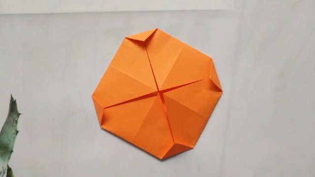 步骤9：接着，平时的饺子皮都是圆的，我们这里折出来的纸是方的，所以，我们再把4个小角往下折一点，这样方形纸就变成圆形纸了